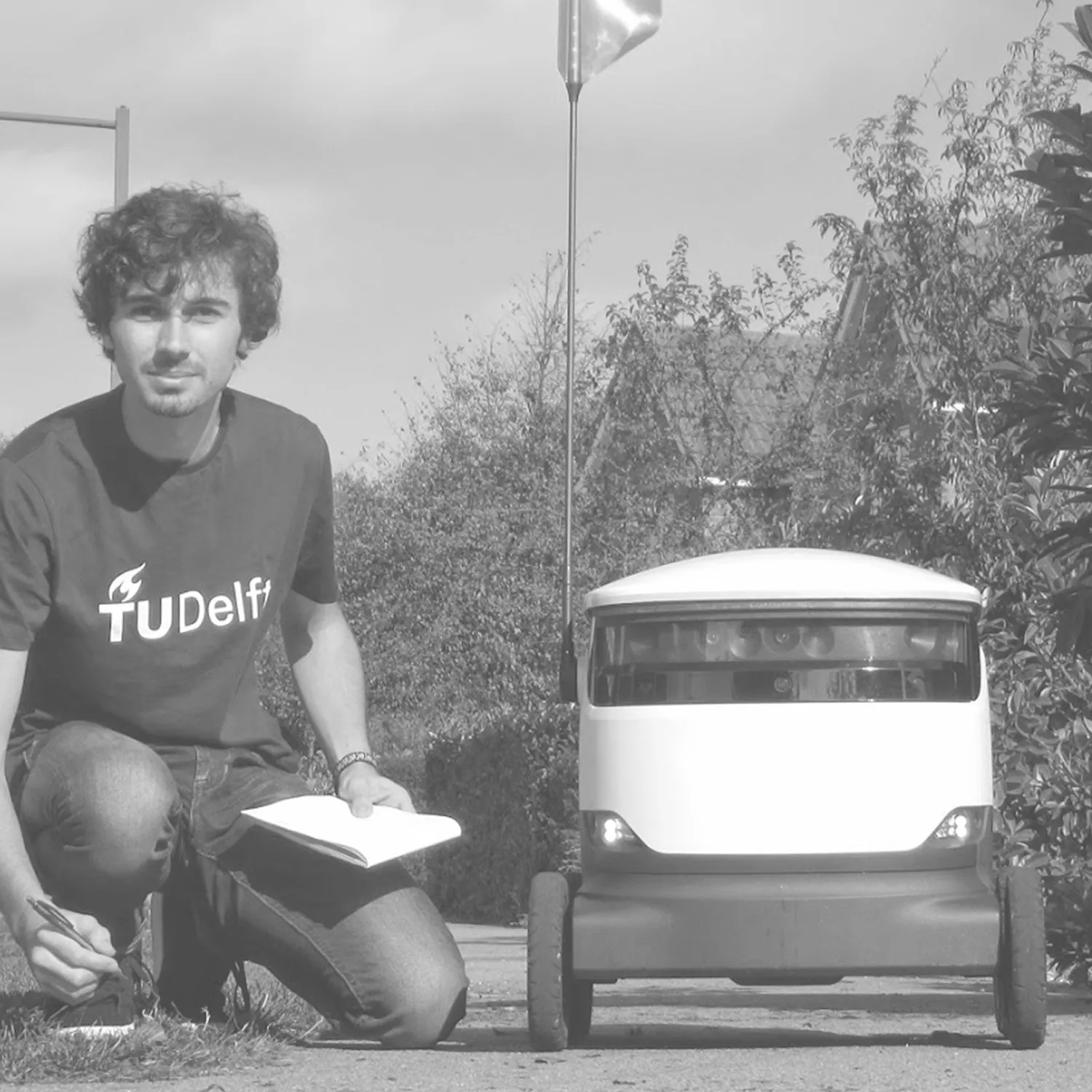 Nyckle crouching next to the delivery robot prototype